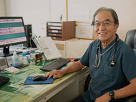 医務室で聴診器を持つ男性職員。介護施設の医療スタッフの職場風景。